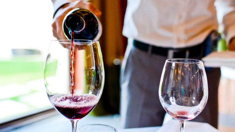 a man pouring a glass of wine