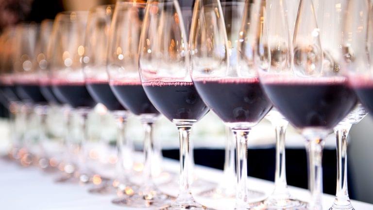 wine lined up in a row on a white table cloth