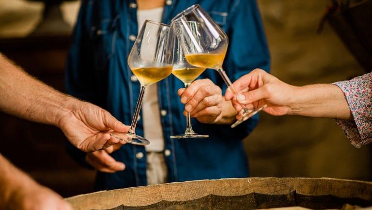 Close up of three hands toasting three glasses of Sauternes