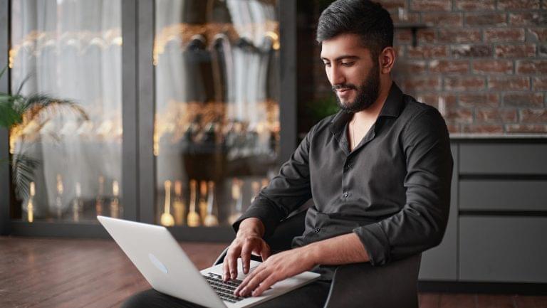 Man in a wine retail setting using a laptop